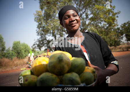 Eine Frau verkauft Obst auf einer belebten Straße in Samendeni, Burkina Faso. Stockfoto