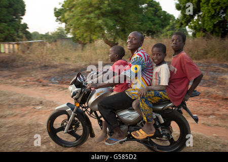 Eine Familie Pfähle auf einem Motorrad zusammen in Siniena Dorf, Banfora Abteilung, Burkina Faso. Stockfoto