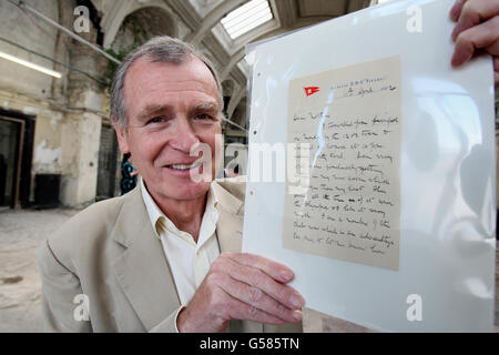 Dr. John Martin der Urneffe von Dr. John Simpson, der auf der Titanic umkam, hält einen Brief von der Titanic in den alten Salon von Harland und Wolff, der diesen Sommer im neuen Besucherzentrum in Belfast, das dem Linienschiff gewidmet ist, ausgestellt wird. Stockfoto