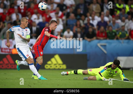 Englands Jamie Vardy (Mitte) hat einen Schuss von Slowakei Torwart Matus Kozacik (rechts) während der UEFA Euro 2016, Gruppe B-Spiel im Stade Geoffroy-Guichard, Saint-Etienne gespeichert. Stockfoto