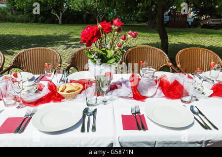 Gartenparty für Mittag-Abendessen mit langen Tisch, dekoriert mit Kerzen im Garten einrichten Stockfoto