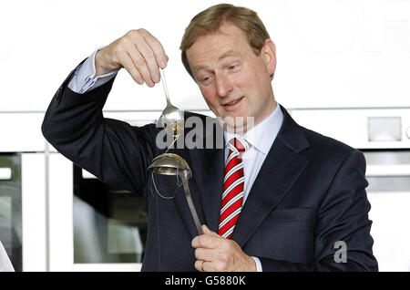 Taoiseach Enda Kenny tropft geschmolzenen Zucker auf einen Löffel, um auf dem Bord Bia Stand beim Bord Bia Bloom Festival im Phoenix Park, Dublin, einen Zuckerkorb zu machen, während die Zählung im Referendum zur Haushaltsstabilität fortgesetzt wird. Stockfoto