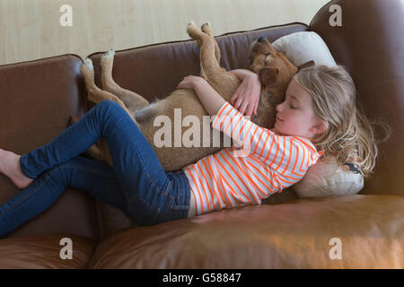 Aussicht von einem jungen Mädchen streicheln ihren Hund auf dem Sofa ein t-Haus. Stockfoto