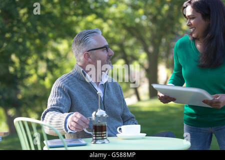 Genießen einen Kaffee in seinem Garten an einem sonnigen Morgen Mann Stockfoto