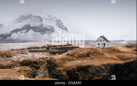 Isländischen Winterlandschaft mit einem weißen kleinen schönen Haus unter dem Berg bei Arnarstapi Snaefellsness-Halbinsel Stockfoto