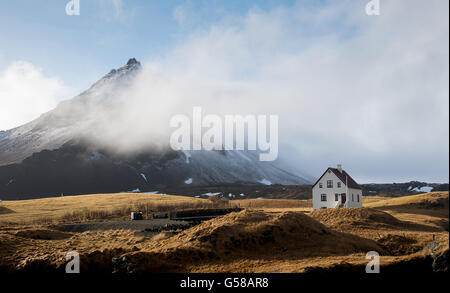 Typische isländische Landschaft mit einem weißen kleinen schönen Haus unter dem Berg bei Arnarstapi Dorf Snaefellsness Halbinsel Stockfoto