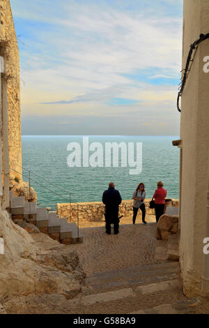 Schmale gepflasterte Straße mit Blick auf das Meer in der Altstadt von Peniscola Spanien Stockfoto