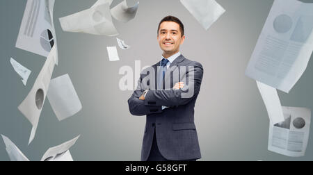 glücklich lächelnd Geschäftsmann im Anzug über Papiere Stockfoto