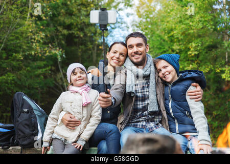 Familie mit Smartphone unter Selfie nahe am Lagerfeuer Stockfoto