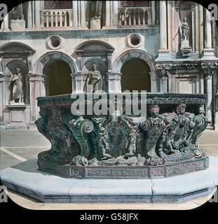 Wir Sehen Den Brunnen als Ein Mächtiges Becken in Kunstvollem Erzguß, Geschmückt Mit Figuren Und Ornamenten. Er ist Im Auftrag der Republik Venedig Im 16. Halbmonatsschrift Angefertigt Und Inzwischen Durch sterben Lange Zeit Mit Einer Wundervollen Grünen Patina Überzogen. Einen Heißen Tagen ist der Brunnen von Lachenden Und Schwatzenden Wasserträgerinnen Umlagert, sterben Aber Nie Vergessen, Auch Das Kleine Becken Für Die Tauben Mit Frischem Wasser Zu Füllen. Reisen, Italien, Venedig, Venetien, Veneto, Geschichte, historisch, Archiv, Carl Simon, 1910er Jahre, 20. Jahrhundert, Brunnen, wohnen, Hof, Dogenpalast, PA Stockfoto