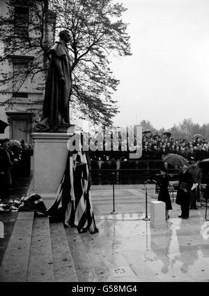 An einem nassen Tag enthüllt die Queen in Carlton Gardens, London, das nationale Denkmal für ihren Vater, den verstorbenen König George VI. Die Statue zeigt den König in Marineuniform. Es ist das Werk des Bildhauers William McMillan. Stockfoto