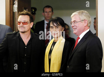 Die birmanische Führerin und Friedensnobelpreisträgerin Aung San Suu Kyi wird von Tanaiste Eamon Gilmore (rechts) und Bono am Flughafen Dublin zu einem sechsstündigen Flugbesuch in die irische Hauptstadt begrüßt. Stockfoto