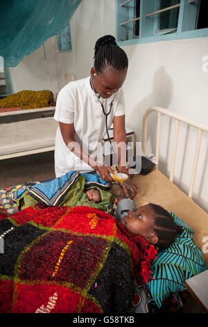 Eine Krankenschwester kümmert sich um ihr neugeborenes Baby in Kigoma Region, Tansania und Patienten. Stockfoto