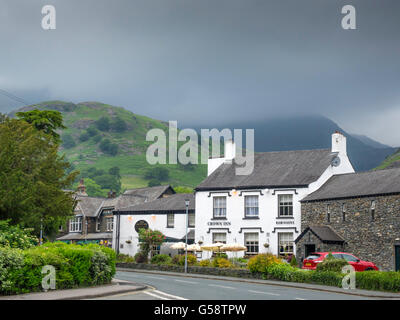 Crown Inn Coniston Cumbria England UK mit dunklen Regenwolken Stockfoto