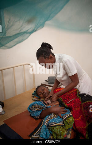 Eine Krankenschwester kümmert sich um ihr neugeborenes Baby in Kigoma Region, Tansania und Patienten. Stockfoto