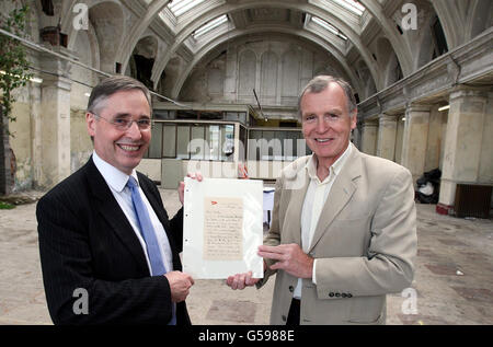 Dr. John Martin (rechts) der Urneffe von Dr. John Simpson, der auf der Titanic ums Leben kam, erhält einen Brief von der Titanic, von Bryan Gregory, dem amtierenden Geschäftsführer der Titanic Foundation, in den alten Salon in Harland und Wolff. Stockfoto