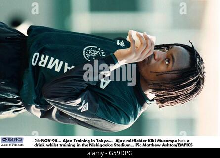 26-NOV-95. Ajax Training in Tokio. Der Ajax-Mittelfeldspieler Kiki Musampa trinkt während des Trainings im Nishigaoka-Stadion einen Drink Stockfoto