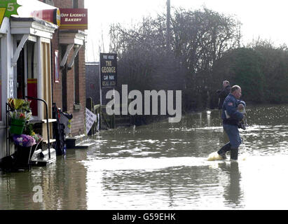 Dorfbewohner in Yalding, Kent, waten durch das Hochwasser zum örtlichen Geschäft. Familien im Dorf, die Ende letzten Jahres die schlimmsten Überschwemmungen erlebt haben, wurden vom Umweltbundesamt gewarnt, dass die Flut zwischen 10 und 12 Uhr morgens Überschwemmungen verursachen könnte * ... entlang der bereits geschwollenen Medway und kleineren Nebenflüssen. Trotz des Endes der starken Regenfälle kann das Wasser nicht fließen, und die Bewohner wurden gewarnt, dass sie Überschwemmungen auf einem ähnlichen Niveau wie Ende Oktober letzten Jahres sehen könnten. Stockfoto