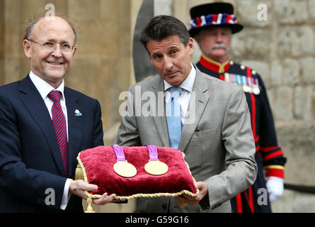 Lord Sebastian Coe (rechts), Vorsitzender des Londoner Organisationskomitees der Olympischen und Paralympischen Spiele, begrüßt den Vorsitzenden von Rio Tinto Jan du Pelessi, da die olympischen Medaillen von Rio Tinto, dem offiziellen Metalllieferanten der Londoner Spiele 2012, an den Tower of London geliefert werden. Für die Lagerung in den Gewölben am Turm. Stockfoto