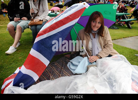 Tennisspieler schützen sich am siebten Tag der Wimbledon Championships 2012 im All England Lawn Tennis Club in Wimbledon vor dem Regen auf Murray Mount. Stockfoto