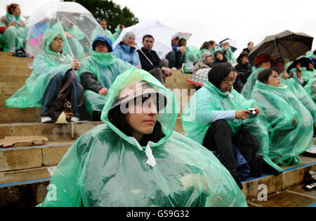 Tennisspieler schützen sich am siebten Tag der Wimbledon Championships 2012 im All England Lawn Tennis Club in Wimbledon vor dem Regen auf Murray Mount. Stockfoto