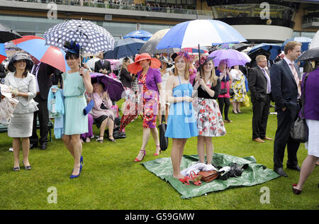 Rennfahrer mit Regenschirmen am dritten Tag des Royal Ascot-Treffens 2012 auf der Ascot Racecourse, Berkshire. Stockfoto