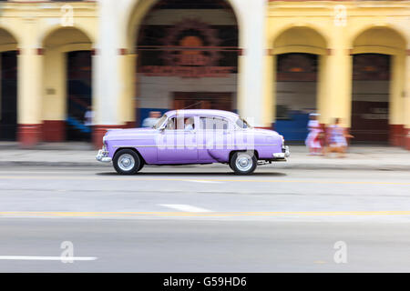 Panning Shot lila amerikanische Oldtimer Reisen in Paseo de Marti, Alt-Havanna, Kuba Stockfoto