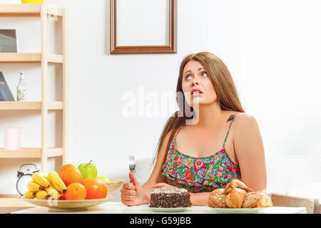 Fette Frau am Tisch nach Hause Stockfoto