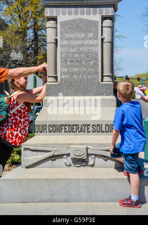 Kinder erkunden ein Denkmal mit konföderierten Soldaten auf, von den Töchtern der Konföderation im Jahre 1899 historischen Franklin, TN Stockfoto