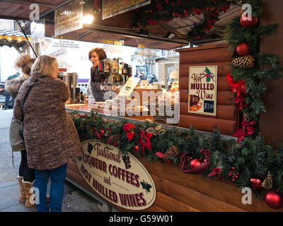 Menschen bei Kaffee und Glühwein Weinmarkt Stand am Weihnachtsmarkt am Albert Square in Manchester, England, UK Stockfoto