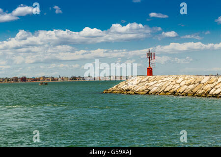 roten Metall Leuchtturm angetrieben durch Solar-Panel auf einer Mole mit der adriatischen Küste und Meer im Hintergrund Stockfoto