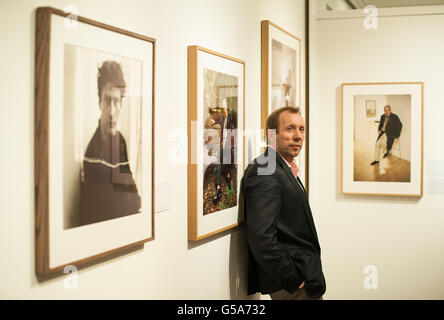 Der Fotograf David Dawson posiert mit Arbeiten aus „an Artist's Life: Photographs of Lucian Freud by Cecil Beaton and David Dawson“, die vom 10. Juli bis 11. August 2012 im Sotheby's in London zu sehen ist. Stockfoto