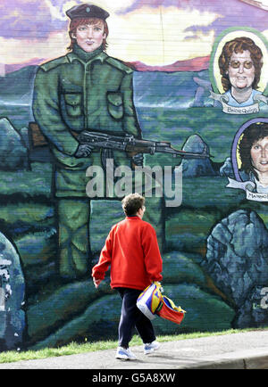 Eine Frau geht an einem IRA Mural im Westen von Belfast vorbei. Die IRA hat den Kontakt mit der internationalen abrüstungskommission erneuert, als der britische Premierminister Tony Blair versuchte, die Sackgasse zu beenden, die die Zukunft des nordirischen Friedensprozesses bedroht. * Sieben Stunden nach der Bekanntgabe einer Entscheidung, mit dem Leiter der Stilllegungsstelle General John de Chastelain neue Gespräche aufzunehmen, bestätigten die Aufsichtsinstanz, dass die Kommunikationswege wieder geöffnet worden waren. Stockfoto