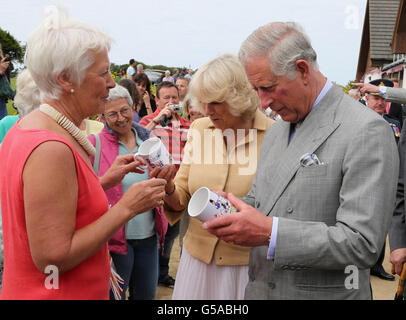 Der Prinz von Wales und Camilla, Herzogin von Cornwall werden mit einem Gedenkbecher des königlichen Besuches von einer Dame namens 'Puffin' auf der Insel Sark überreicht, während sie ihren Besuch auf den Kanalinseln fortsetzen. Stockfoto