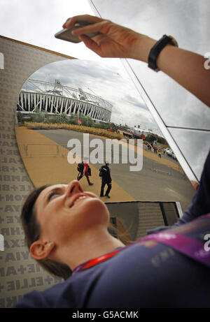 Amanda Smerczak fotografiert das Olympiastadion, das sich in einem Spiegel auf ihrem Smartphone im Olympic Park, Stratford, London, widerspiegelt, während die Vorbereitungen für die Olympischen Spiele 2012 in London weitergehen. Stockfoto