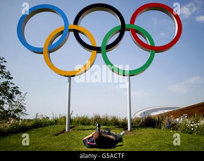 Ein Fotograf fotografiert die olympischen Ringe neben dem Velodrom, während die letzten Vorbereitungen im Olympic Park in Stratford, London, weitergehen. Stockfoto