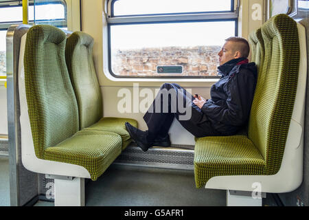junger Mann Füße Fuß Sitz Sitze Zug Wagen uk Stockfoto