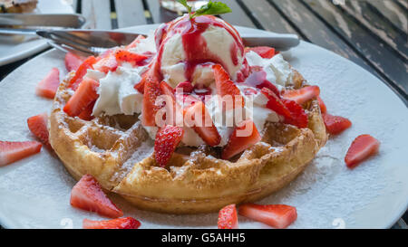 Waffeln mit frischen Erdbeeren und Eis auf weißen Teller Stockfoto