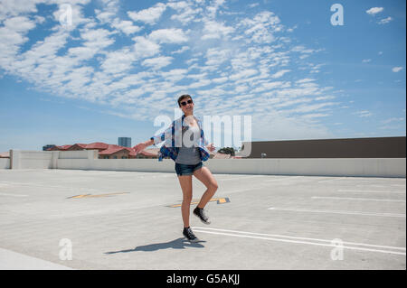 Moderne Teenager in Sonnenbrille läuft sorglos Stockfoto