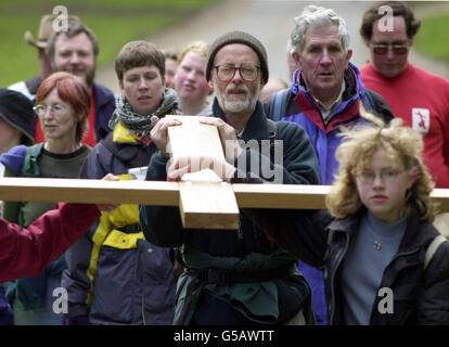 Pilger, die zur 'Shrine der Muttergottes' in Walsingham, Norfolk, wandern und ein Holzkreuz durch das Dorf North Barsham tragen, Karfreitag. Stockfoto