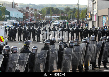 Demonstranten sehen sich nach einer Parade der Orangenen Orden in Nord-Belfast der Polizei in Ardoyne gegenüber. Stockfoto