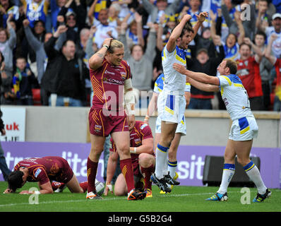 Rugby League - Stobart Super League - Warrington Wolves gegen Huddersfield Giants - Halliwell Jones Stadium. Stefan Ratchford von Warrington Wolves feiert mit Micky Higham, als der Huddersfield Giants' Eorl Crabtree niedergeschlagen wirkt Stockfoto