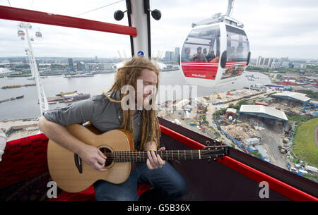 Newton Faulkner spielt einen exklusiven Gig für die Sieger des Wettbewerbs in einer der olympischen Emirates Air Cable Cars, die die Themse im Osten Londons überqueren. Stockfoto