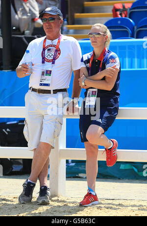 Die britische Zara Phillips plaudert mit ihrem Vater und US-Teamtrainer Mark Phillips im Dressurviereck während der Reittrainingsession im Greenwich Park, London. Stockfoto