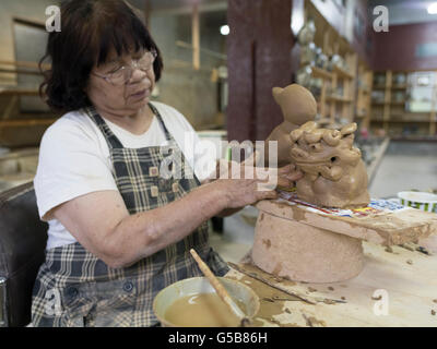 Sumiko Miyagi erstellen Keramik Shisa am Yachimun no Sato (Keramik / Artists Village) in Yomitan, Okinawa, Japan Stockfoto