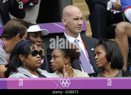 First Lady Michelle Obama (ganz rechts) mit der US-Amerikanerin Venus Williams (links) während des Spiels der US-Amerikanerin Serena Williams in der ersten Runde der Frauen-Singles im olympischen Tennisstadion Wimbledon. Stockfoto