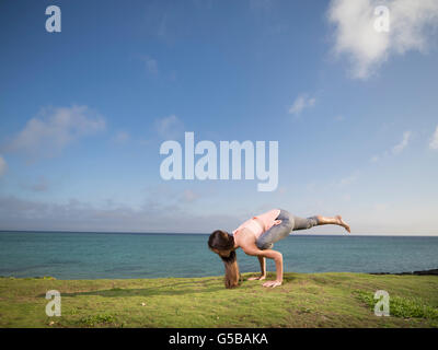 Junge Frau praktizieren Yoga am Strand von Motobu, Okinawa, Japan Stockfoto