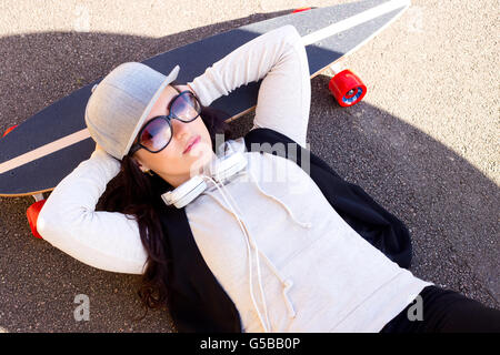 junge Frau mit ihrem Skateboard entspannen Stockfoto