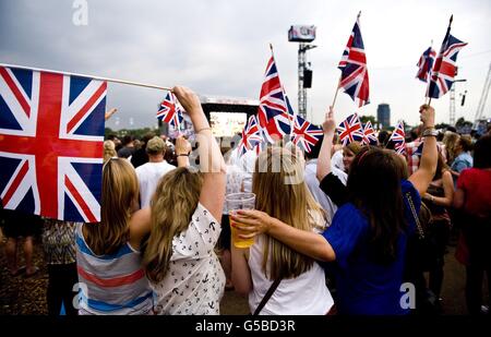 Beim BT London Live-Konzert im Hyde Park, London, sehen die Zuschauer die Eröffnungszeremonie der Olympischen Spiele 2012 auf einer Großleinwand. Stockfoto