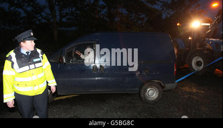 Die Shell to Sea-Aktivistin Maura Harrington wird von einem Erdbeweger abgeschleppt, nachdem sie auf dem Weg zur Shell Bellanaboy Gasraffinerie in Co Mayo den Weg eines Konvois mit Tunnelbohrmaschinen blockiert hat. Stockfoto